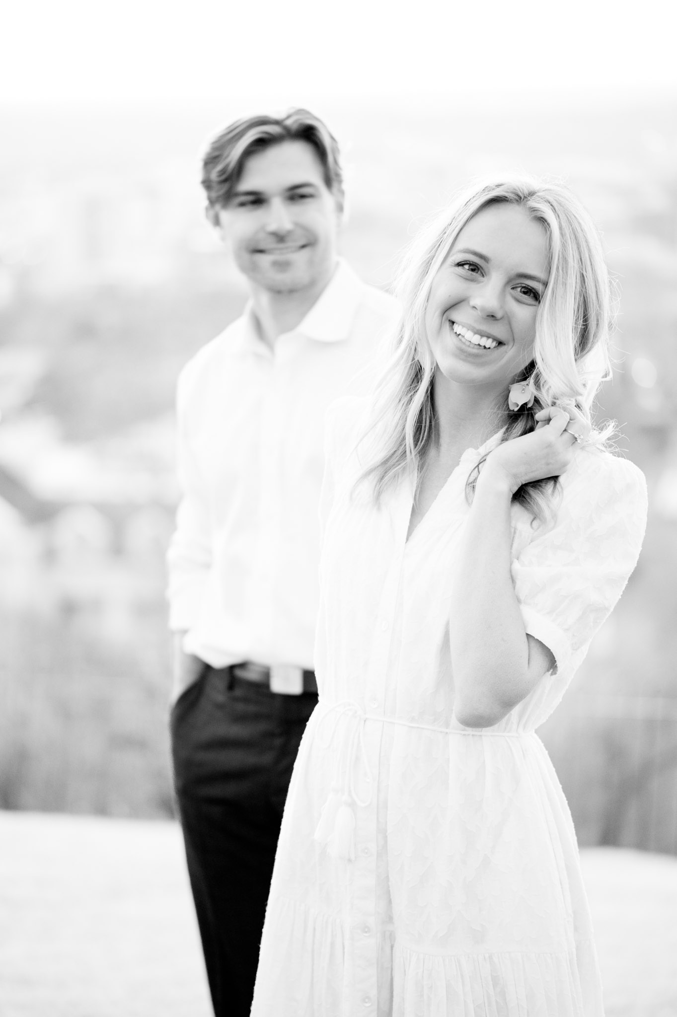 Bride smiles as fiance looks at her.