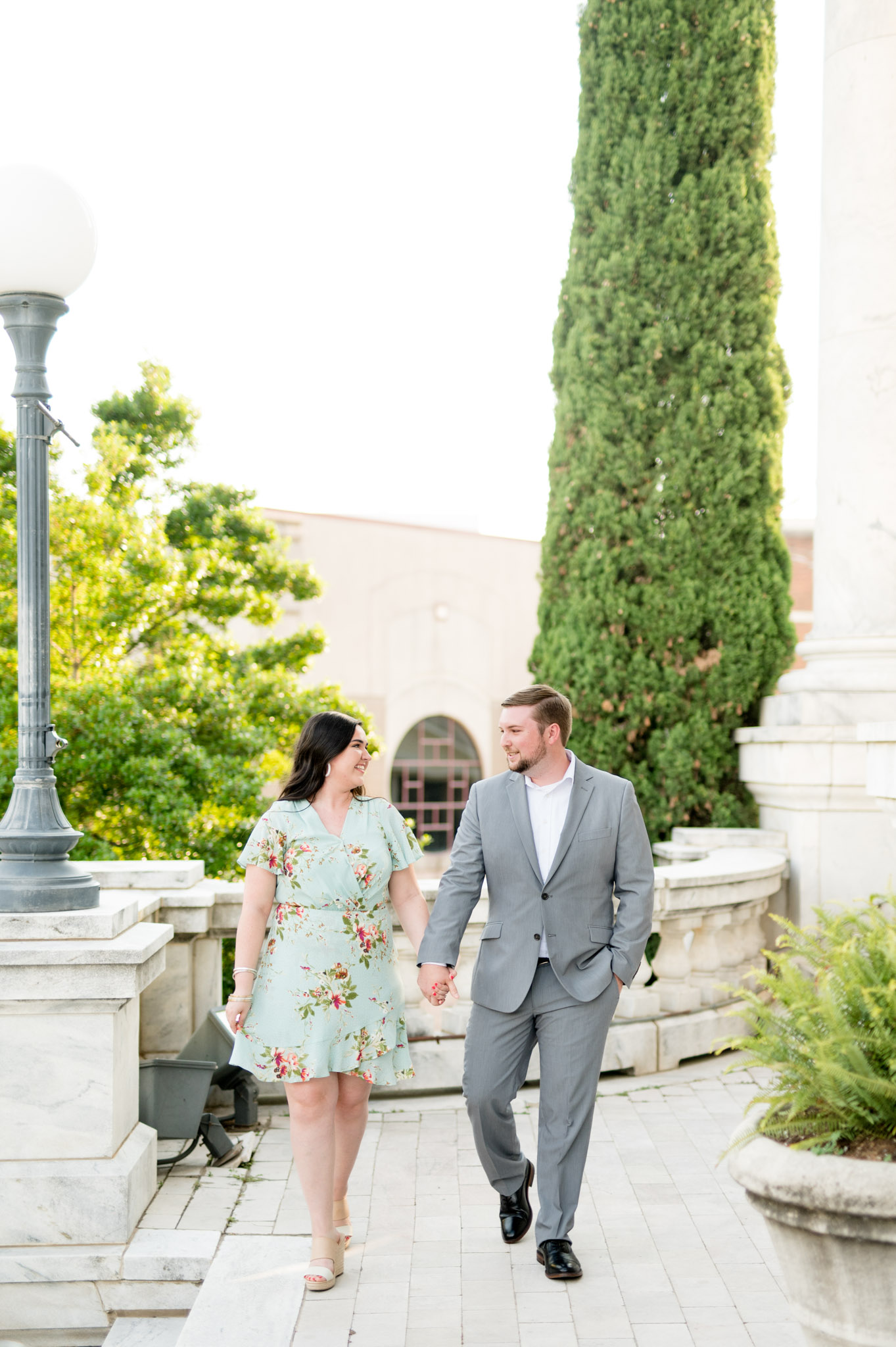 Couple walks across marble balcony.