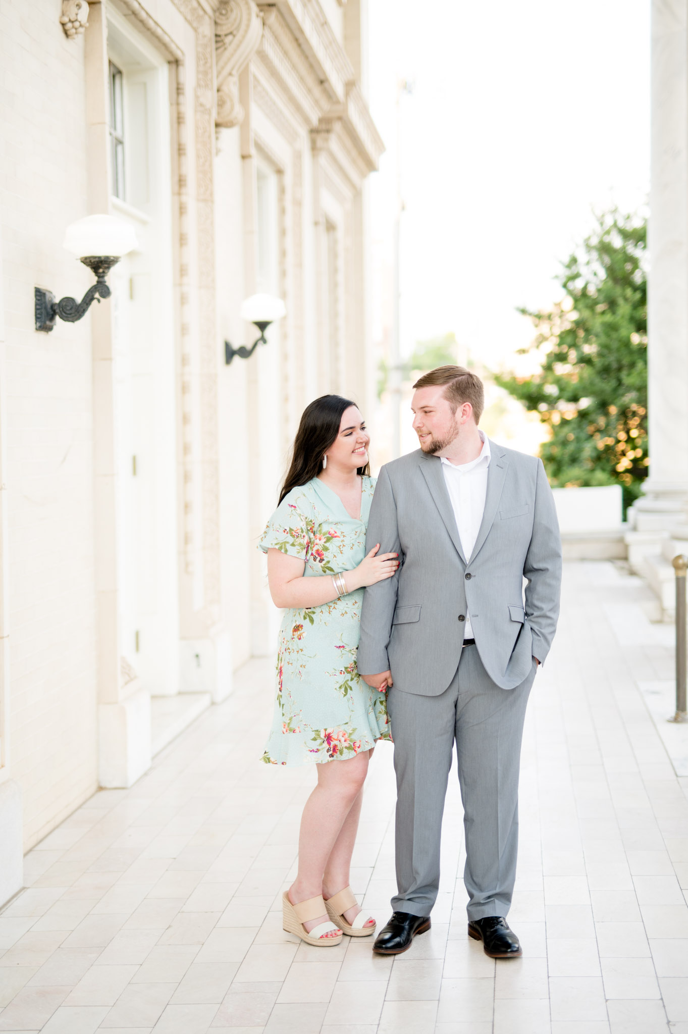 Couple smiles at each other in atrium.