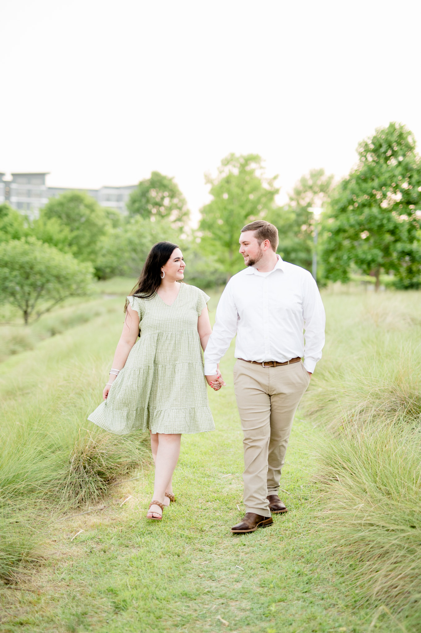 Couple walks along field path.