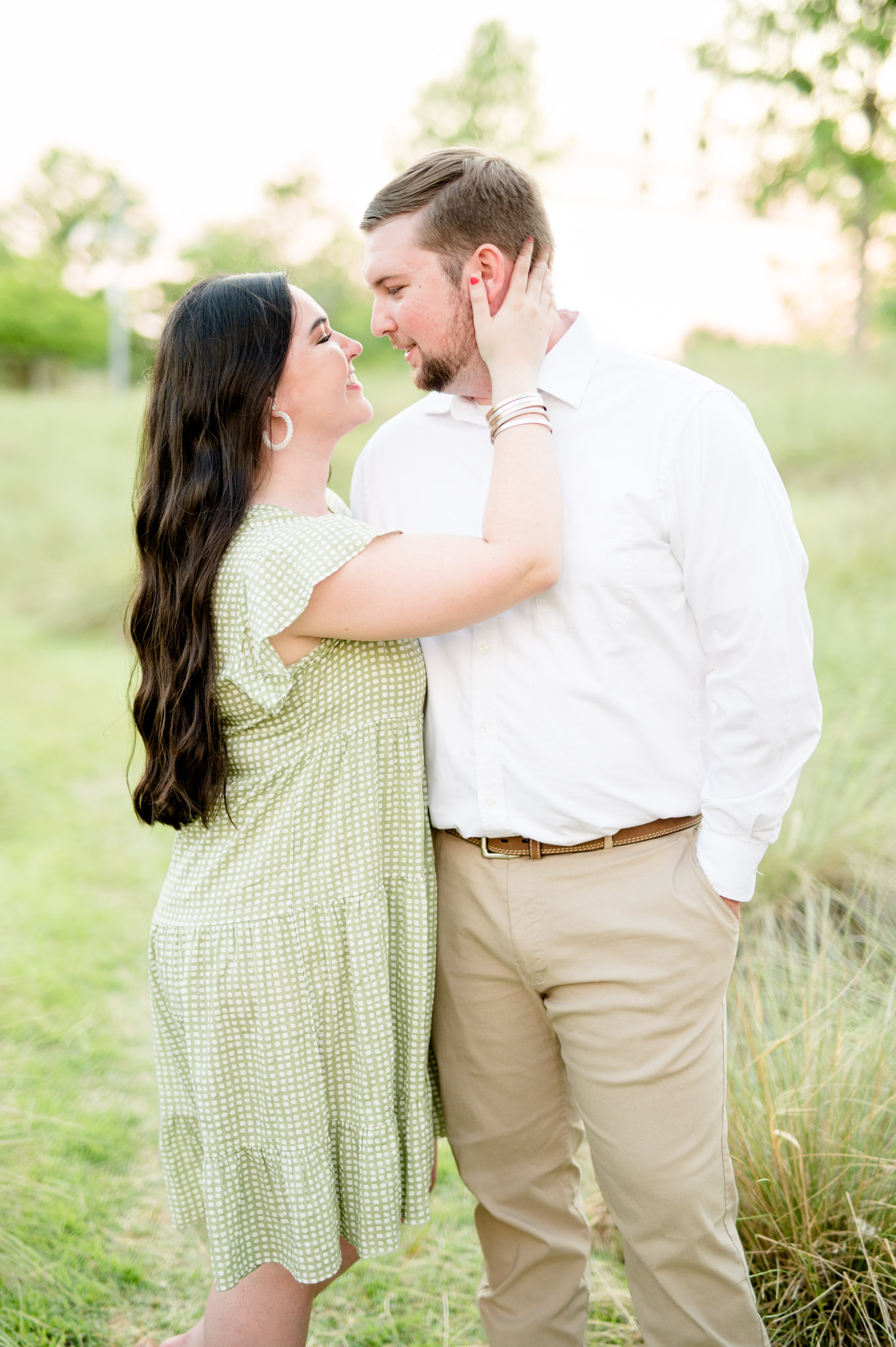 Couple leans in for kiss at sunset.