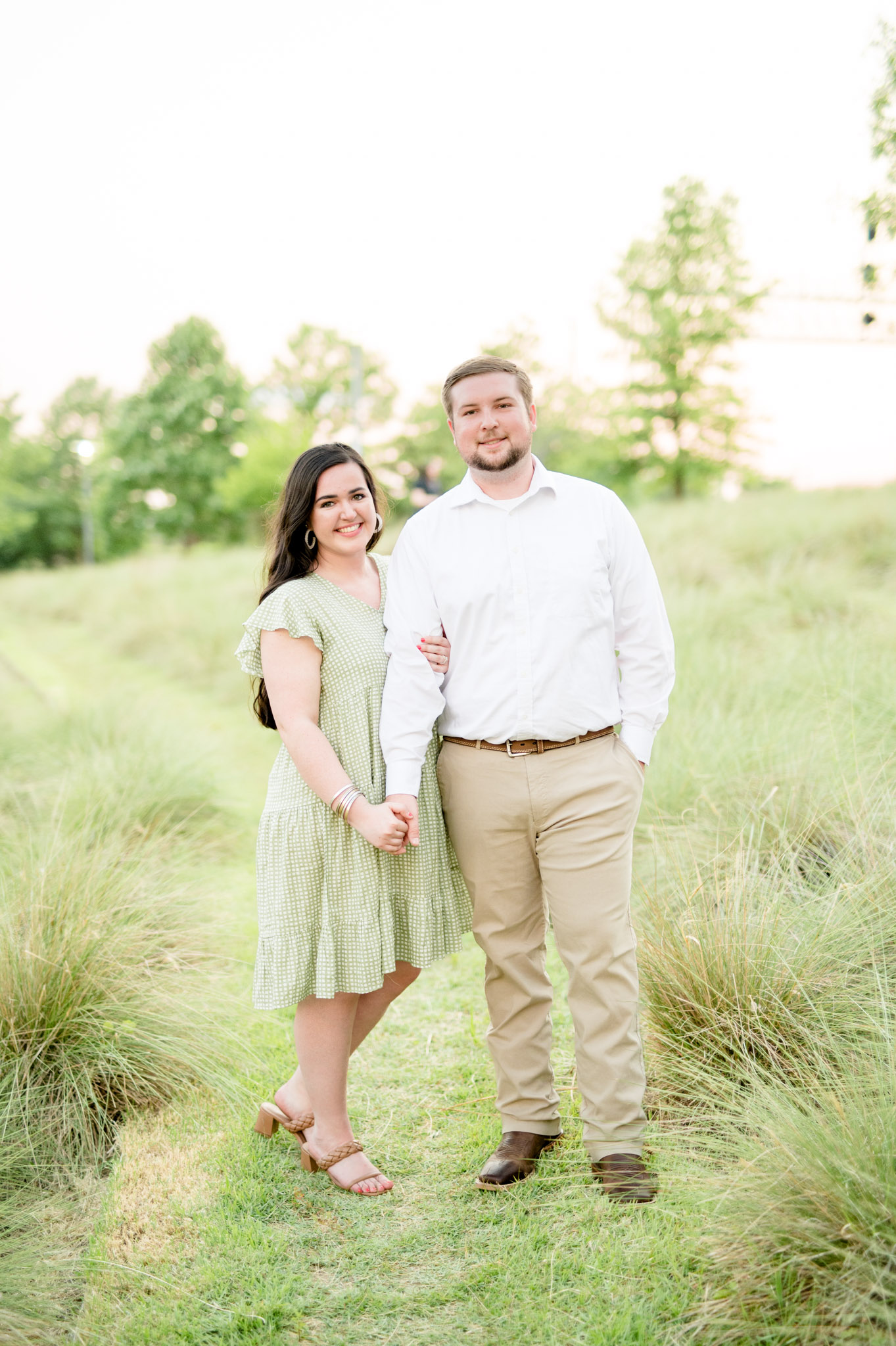 Couple smiles at camera at sunset.