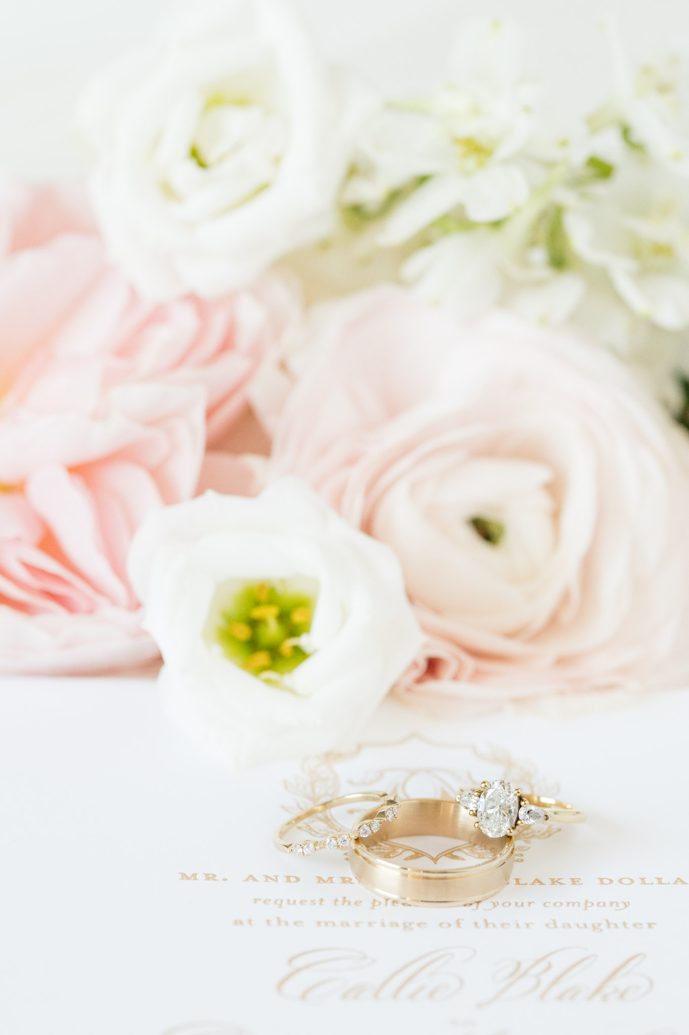 Wedding rings sit with flowers.