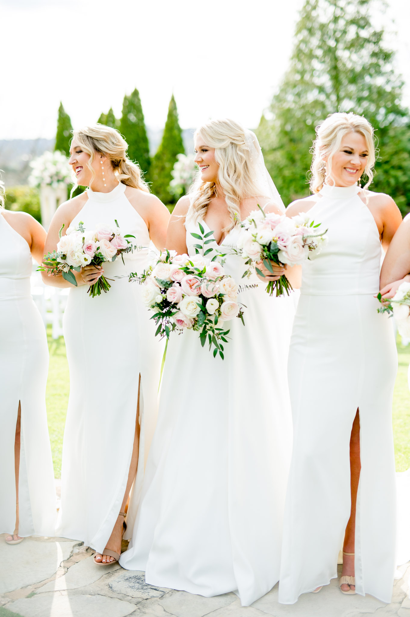 Bride laughs as she walks with bridesmaids.