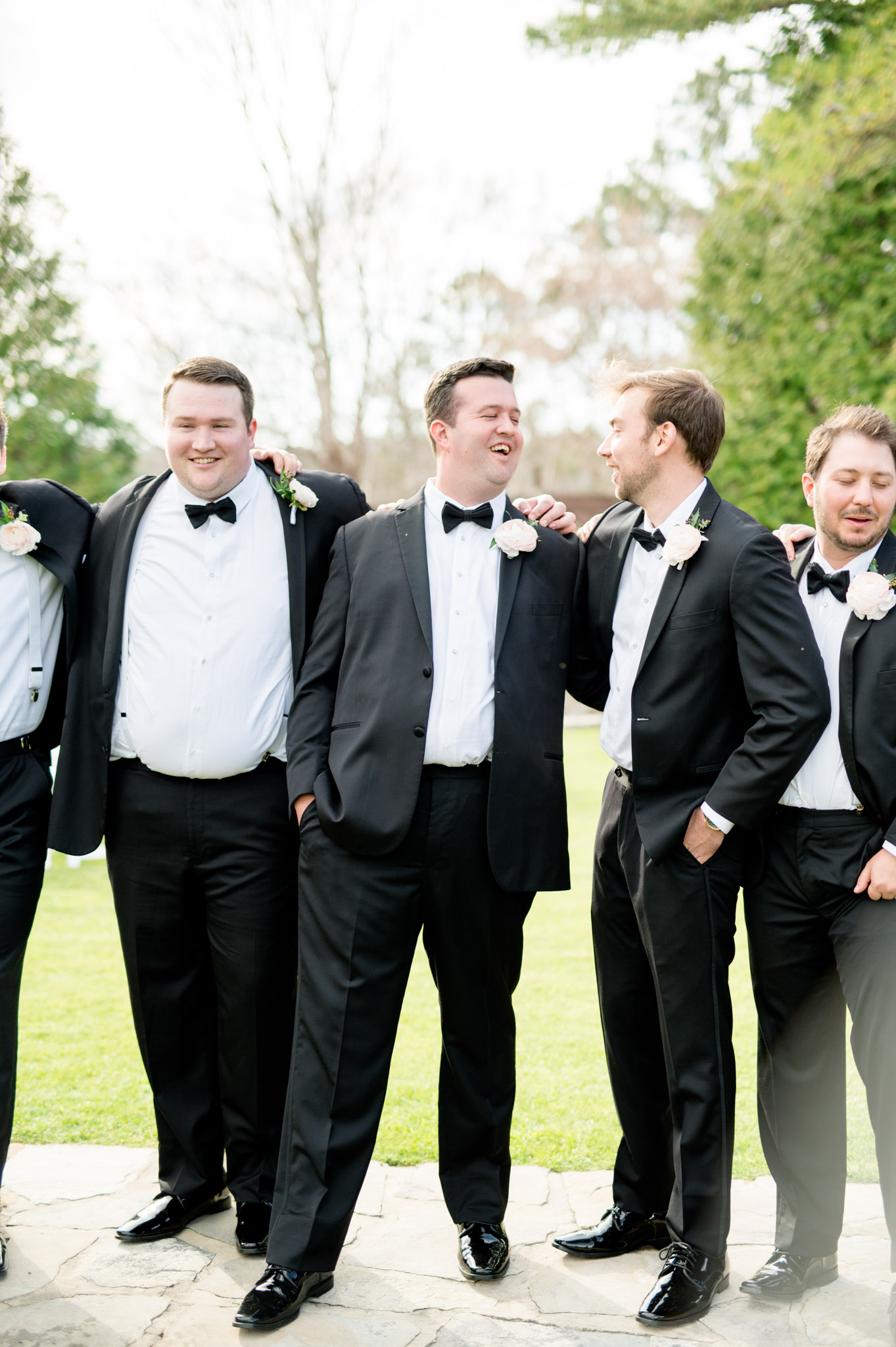 Groom laughs with groomsmen.