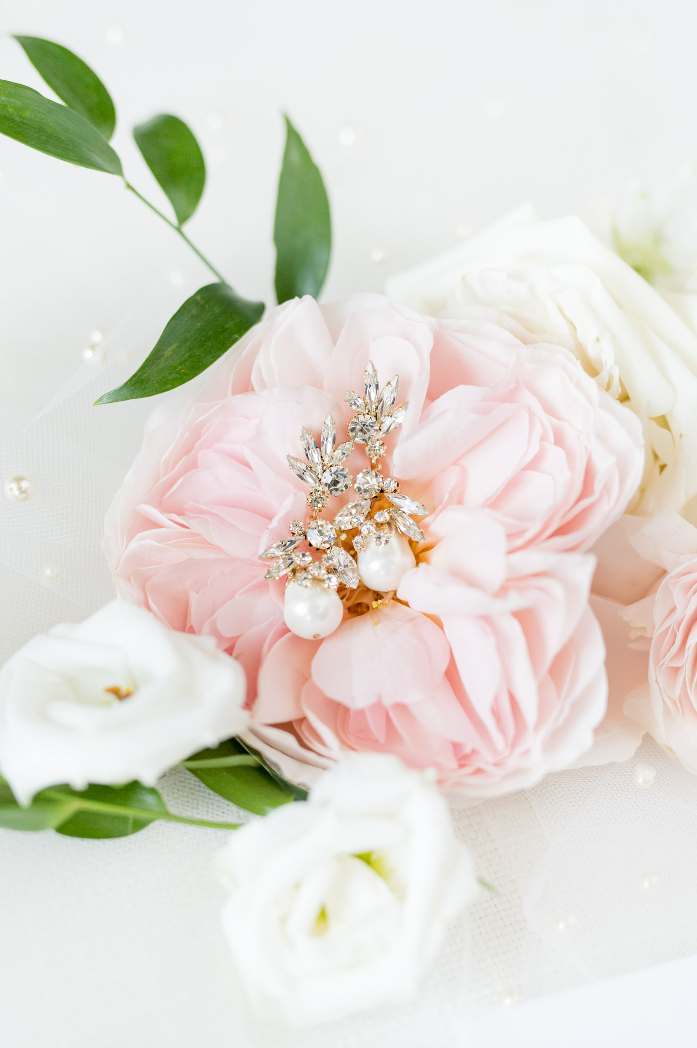 The bride's earrings sit on flowers.