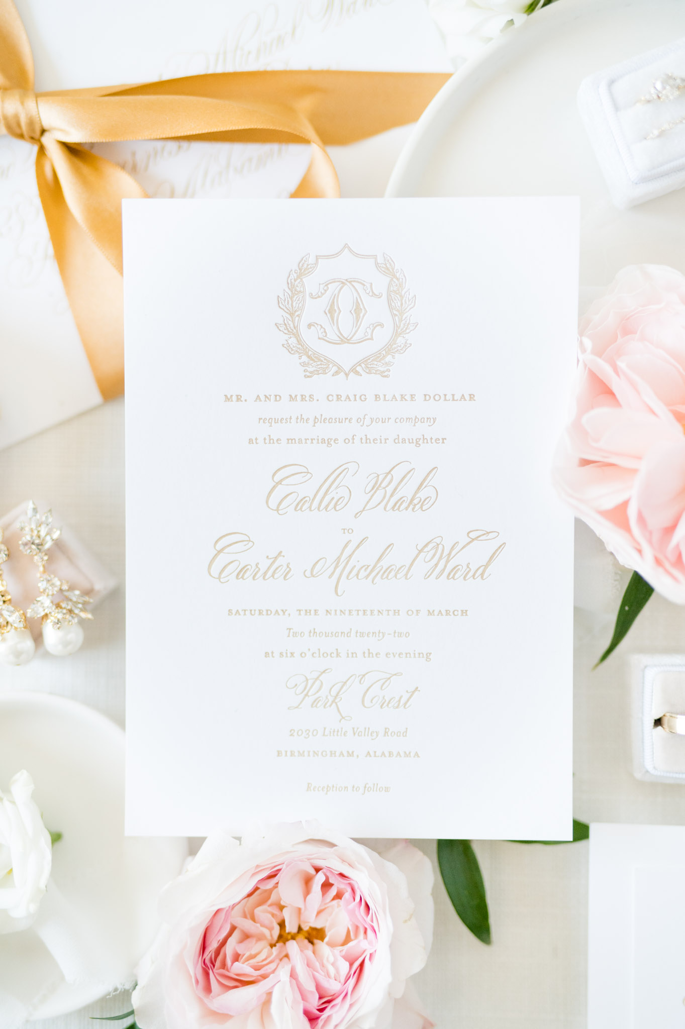 Close up of wedding invitation with monogramed crest.