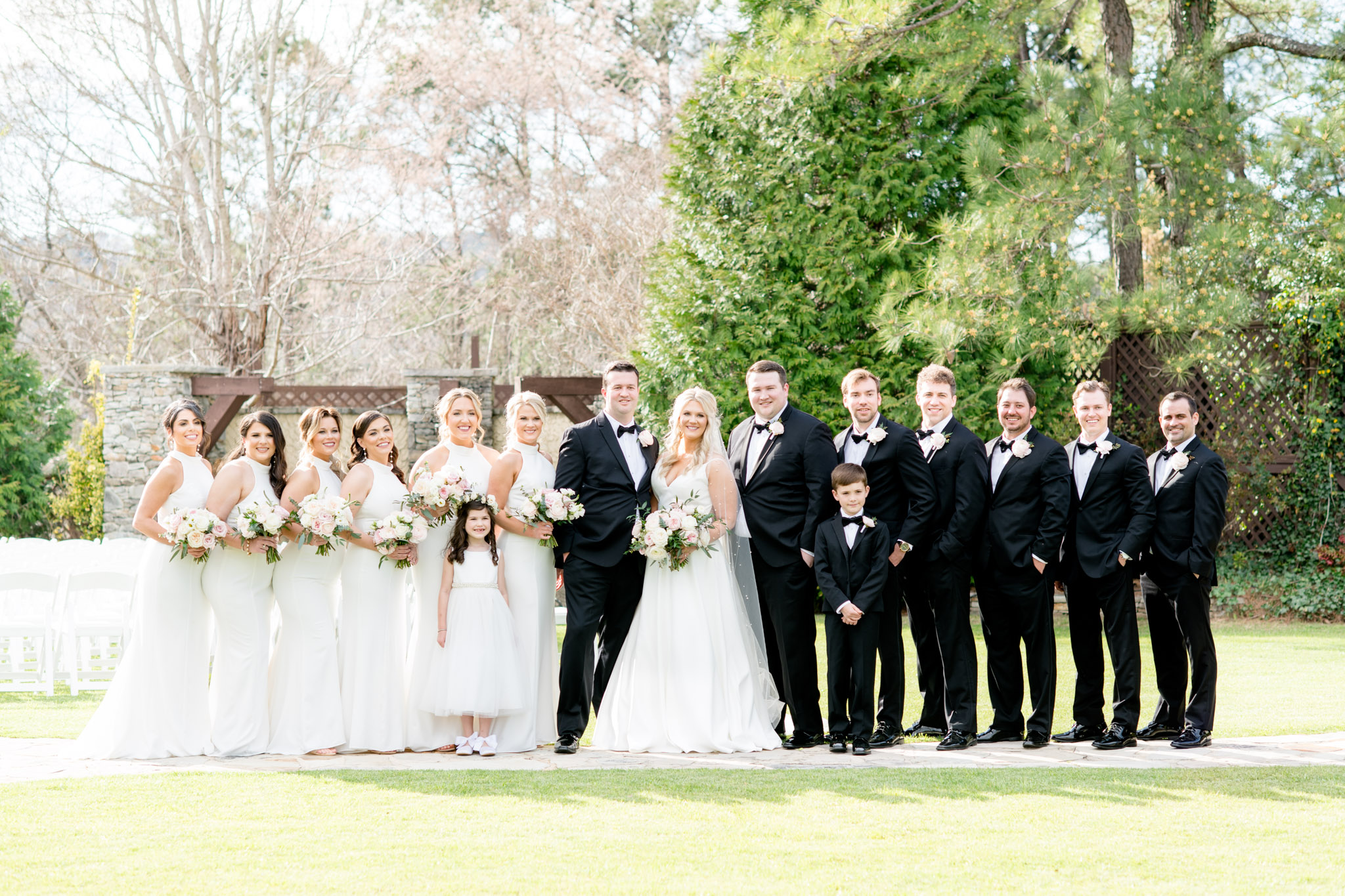 Wedding party smiles at camera together.