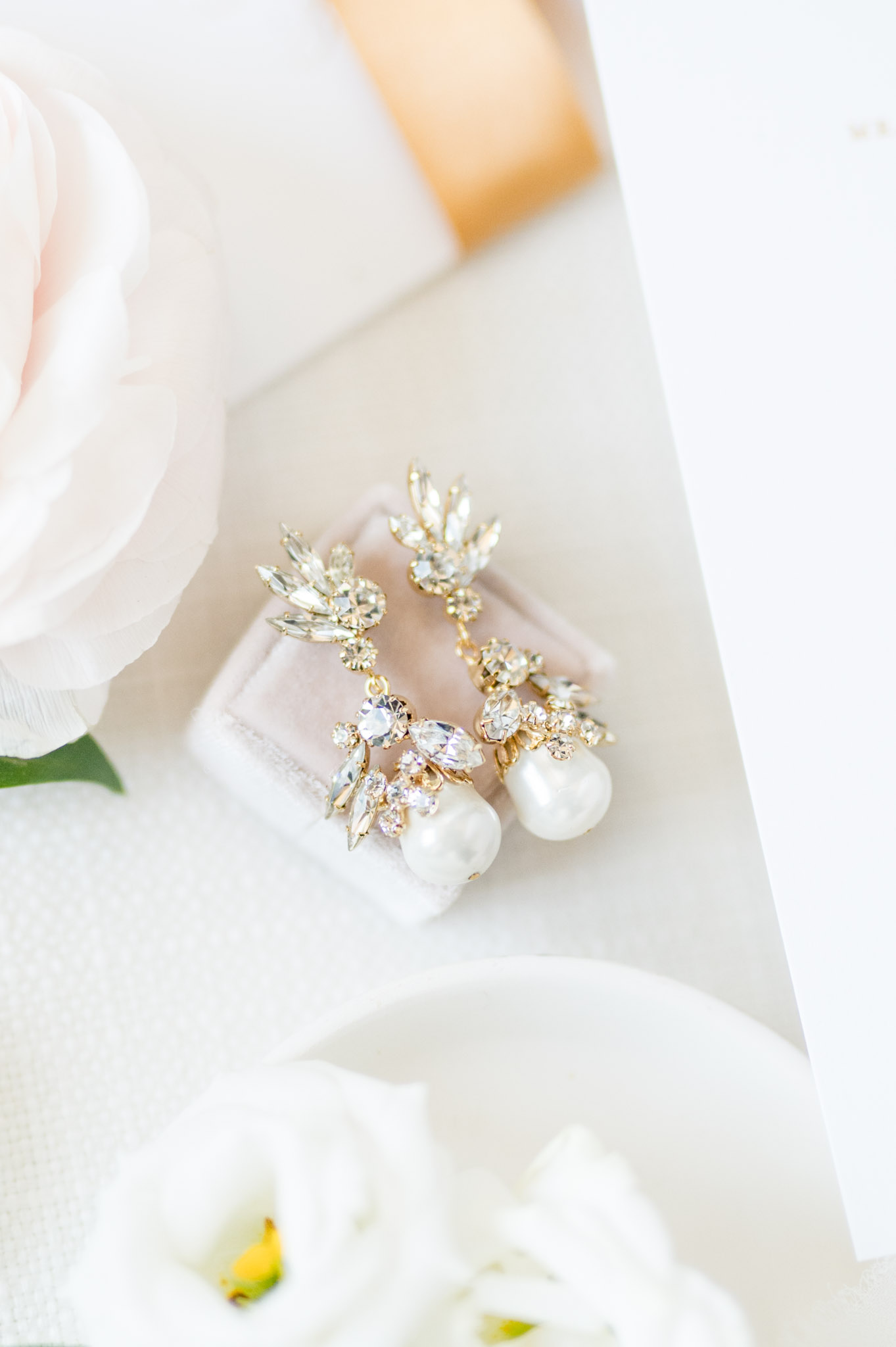 Bride's earrings sit on velvet box.