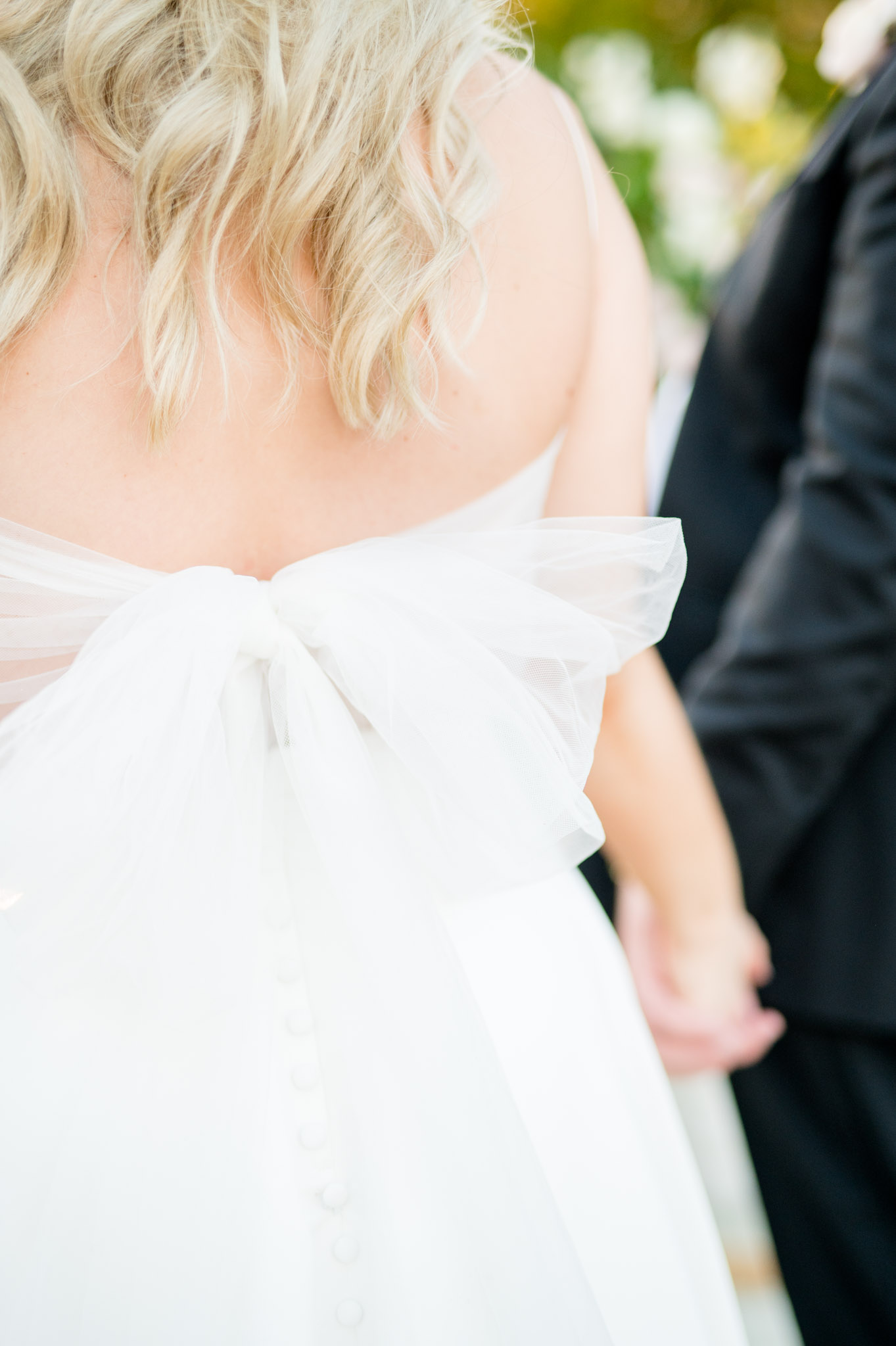 Close up of bow on back of bride's dress.