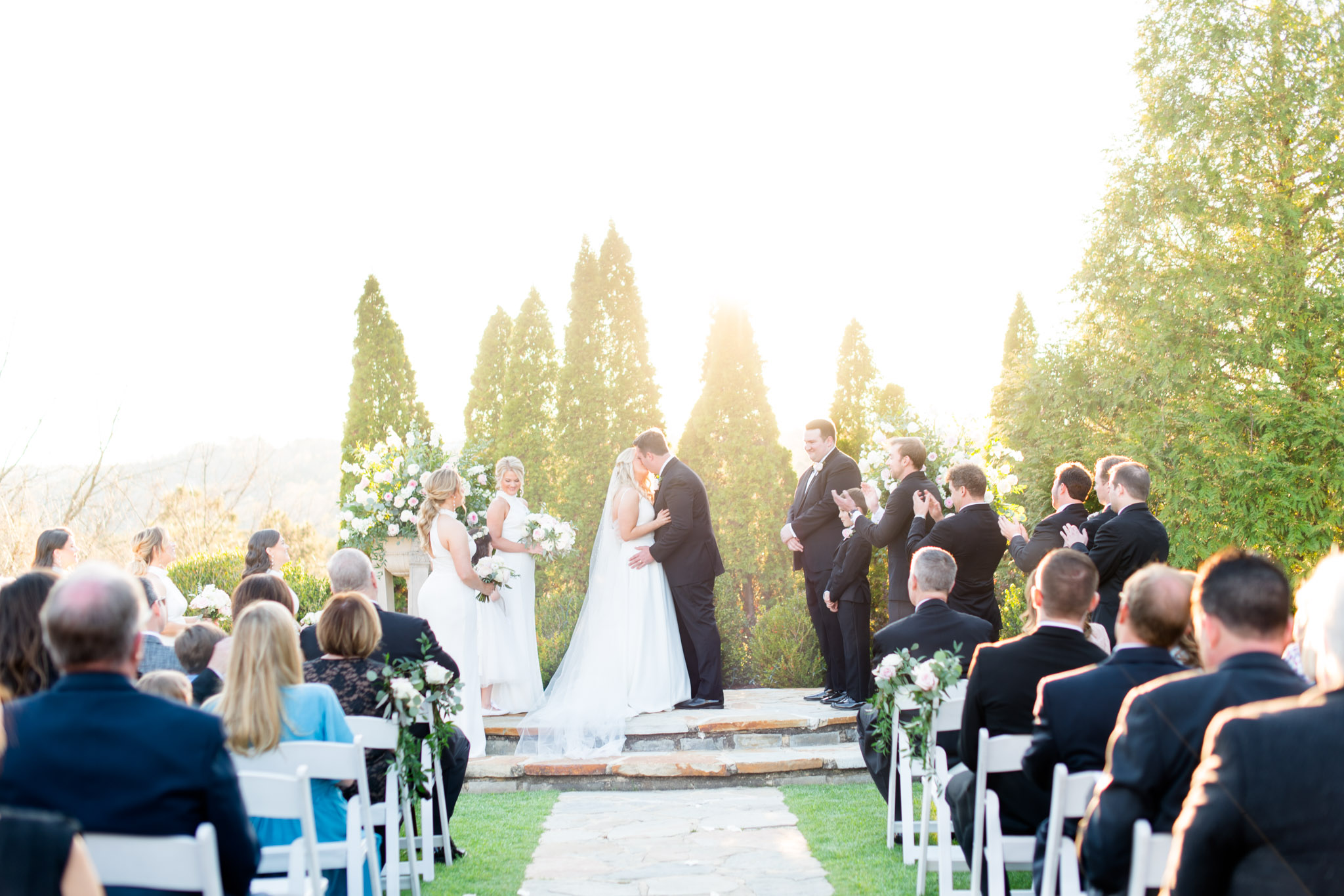 Bride and groom kiss during wedding ceremony.